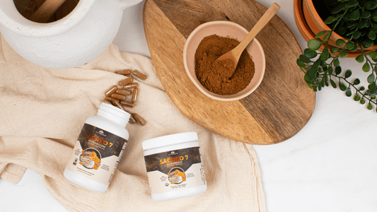 Sacred 7 Mushroom Extract Powder and Capsules in bowl of powder and capsules on kitchen countertop with green plant in right corner