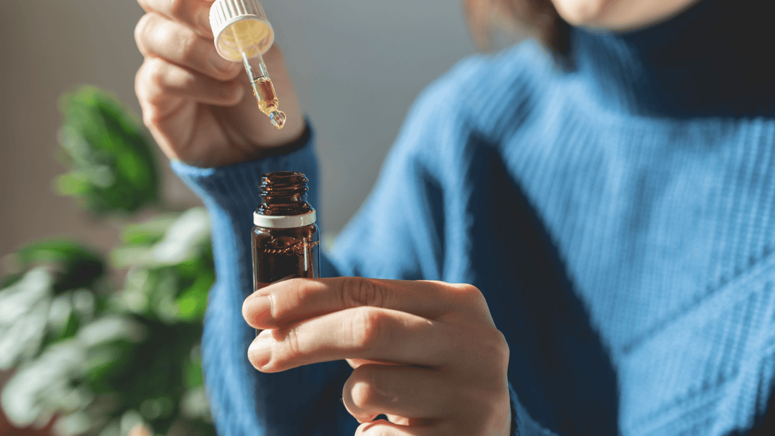 Woman holding tincture with drops into dropper in sunlight