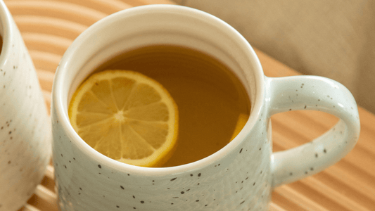 Hot water first thing in morning in mug with mushroom powder and orange slice inside