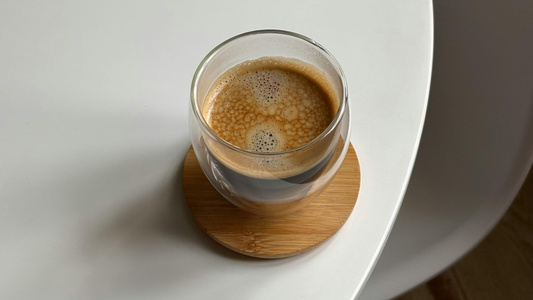 Single homemade coffee on coaster on home kitchen table
