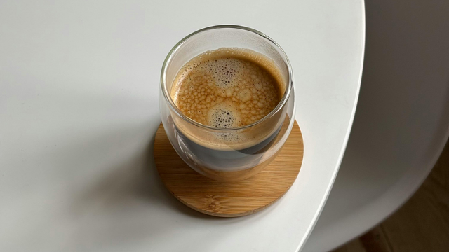 Single homemade coffee on coaster on home kitchen table