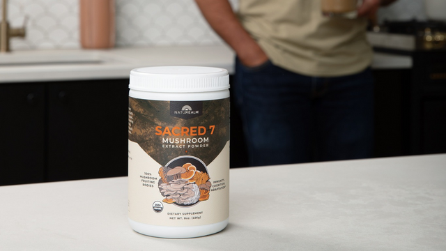 Sacred 7 Mushroom Extract Powder on countertop with man in background